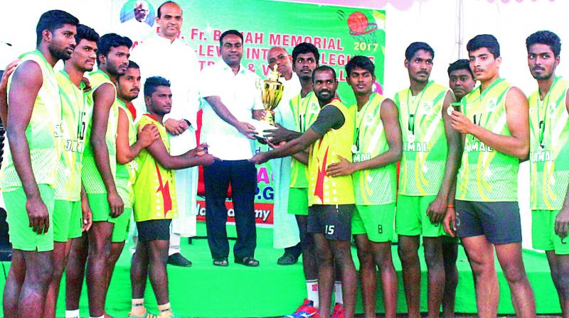 Members of Jamal Mohamed College, Trichy receiving the cup from Fr. Alex S.J. (left). They won the Fr. T. Balaiah memorial All India Inter-Collegiate Volleyball title.