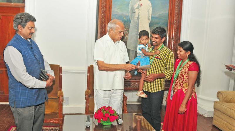 Governor presents visitors certificate to a family  visiting Raj Bhavan in the company of his secretary R.Rajagopalan. (Photo: DC)