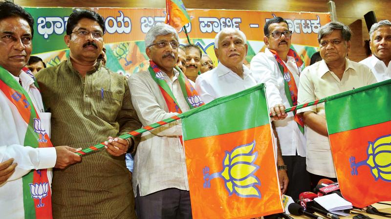 BJP leaders B.S. Yeddyurappa and R. Ashok welcome former MP Jayaprakash Hegde and other leaders who joined the party in Bengaluru on Wednesday