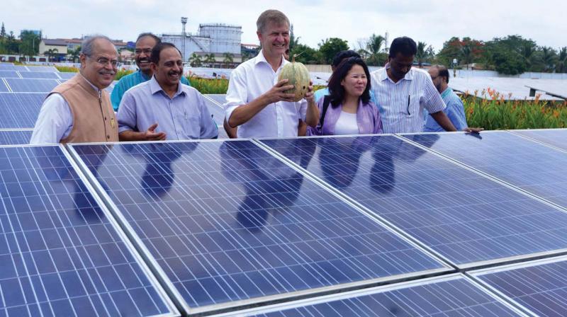 UN environment programme global chief Erik Solheim holds a pumpkin harvested in the area between solar panels at CIALs solar facility, in Kochi on Saturday.