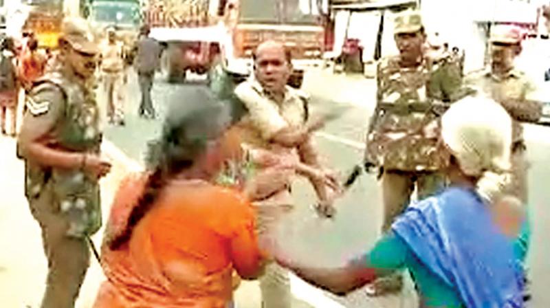 A video grab shows DSP Pandiarajan assaulting a woman protester in Tirupur on Tuesday. (Photo: DC)