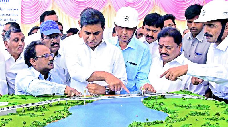 Hyderabad muncipal administration minister K.T. Rama Rao discusses the plan of the bridge over the Durgam Cheruvu lake, during the foundation stone laying ceremony on Wednesday. (Photo: DC)