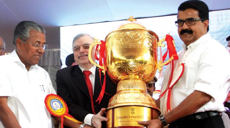 Chief Minister Pinarayi Vijayan and Governor P.Sathasivam hand over the Chancellors Trophy to MG University vice-chancellor Dr Babu Sabastian at MG. University campus in Kottayam on Thursday (Photo: DC)