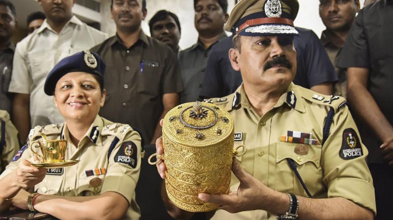 Hyderabad Police Commissioner Anjani Kumar along with a senior police officer shows to media the three-tier golden tiffin box and a golden cup after their recovery. (Photo: PTI)