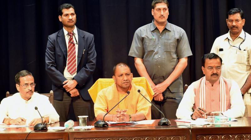 UP Chief Minister Yogi Adityanath with Deputy CMs Dinesh Sharma and Keshav Prasad Muriya at a meeting of police officers at Lok Bhawan in Lucknow. (Photo: PTI)