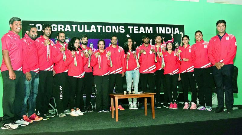 Players, coaches and support staff of Indias badminton contingent at the Commonwealth Games are all smiles at the Pullela Gopichand Badminton Academy in Hyderabad on Tuesday. (Photo: R. Pavan)
