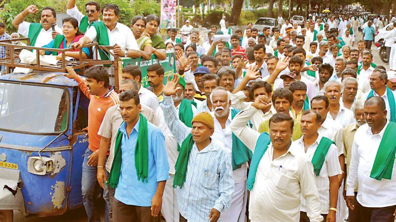 Farmers led by MLA K.S. Puttannaiah take out a rally in Mandya on Monday against the release of Cauvery water to Tamil Nadu. (Photo: KPN)