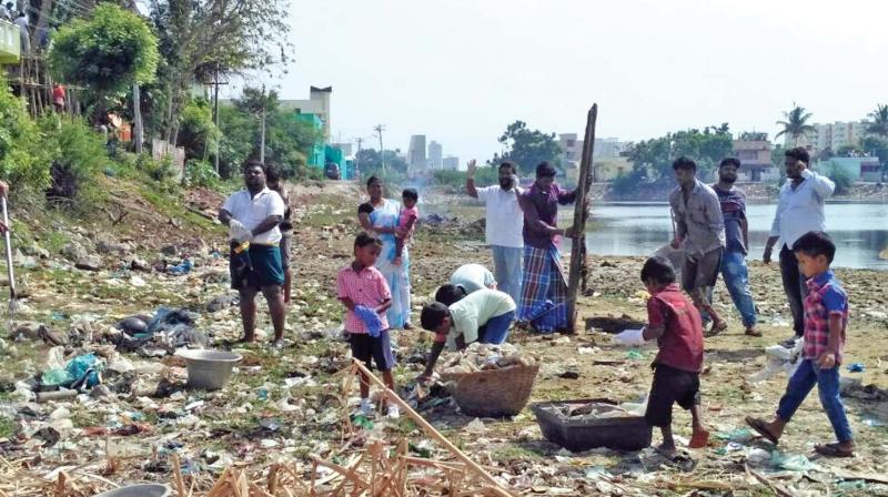 Children along with volunteers help to clean Periyakulam, a ten-acre water body at Padur, on Sunday. (Photo: DC)