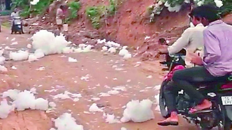 Locals travel through the toxic foam released from the Ramakrishna Puram lake