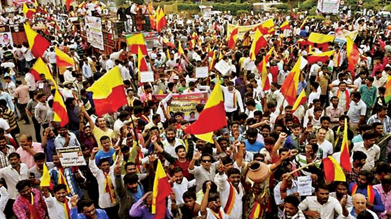 Pro-Kannada activists wave the state flag at a protest against the use of Hindi in Metro Stations
