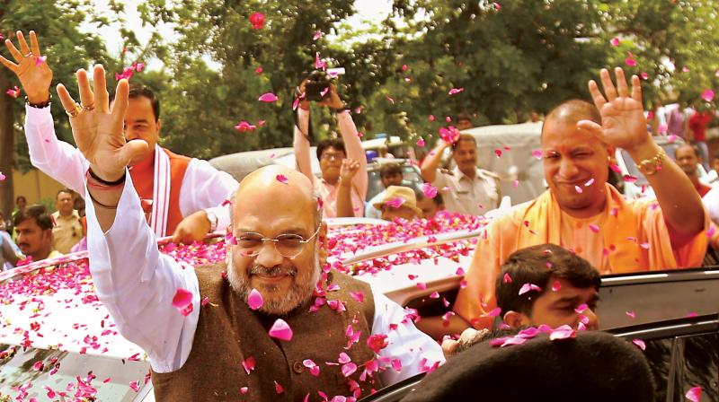 BJP national president Amit Shah and UP Chief Minister Yogi Adityanath greet party workers at Lucknow airport on Saturday 	(Photo: PTI)