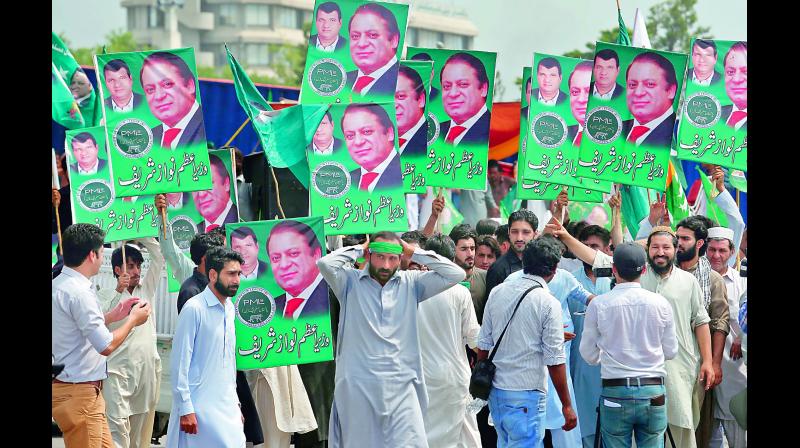 Supporters of former Pakistan PM Nawaz Sharif hold posters duirng a rally in Islamabad (Photo: AP)