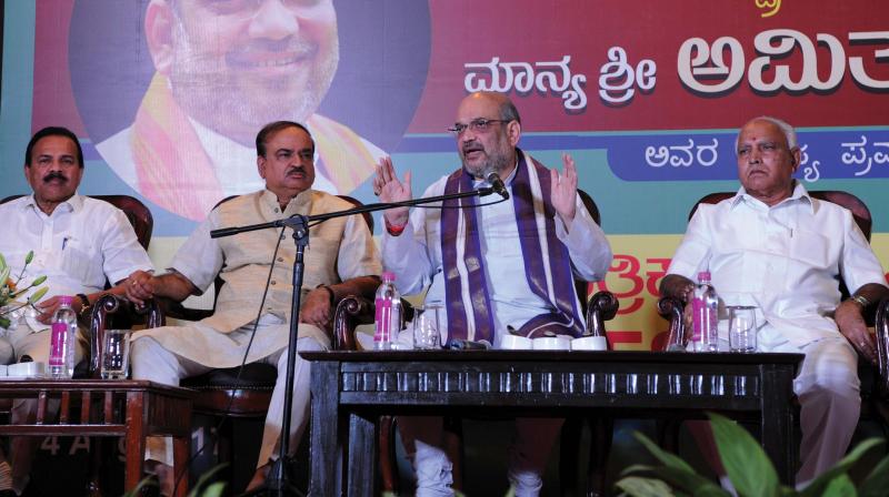 BJP president Amit Shah addresses the media along with state party leaders B.S. Yeddyurappa and H.N. Ananth Kumar in Bengaluru on Monday (Photo: DC)
