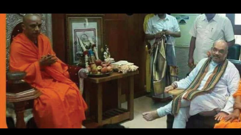 Cross-legged BJP president Amit Shah in conversation with Nirmalanandanatha Swami of Adichunchanagiri Mutt at Nagamangala near Mysuru on Sunday 	(Photo: DC)