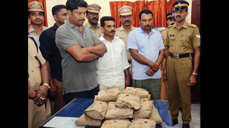 Cops exhibit the hashish oil along with Shino, Biju and Anjumon arrested in connection with the seizure of the narcotic (Photo :DC)