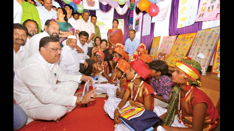 Minister Tanveer Sait with children of mahouts at the tent school on Mysuru Palace premises on Monday 	(Photo: KPN)