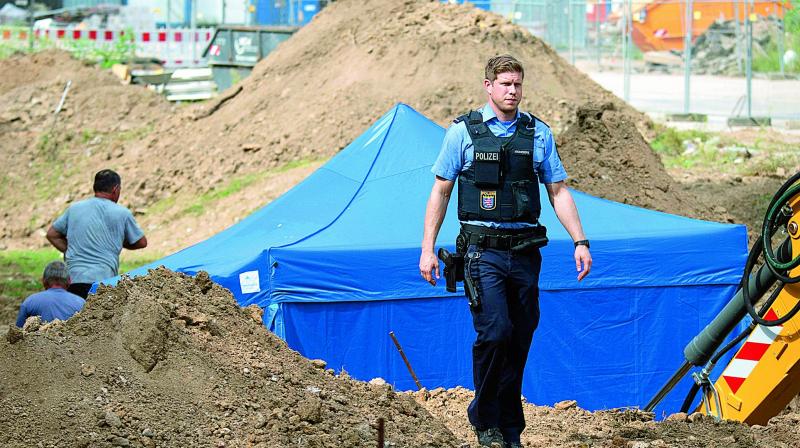 A police officer passes by a blue tent which was set up over a 1,400-tonne bomb dropped by British bombers during World War II, in Franfurt, on Thursday (Photo: AP)