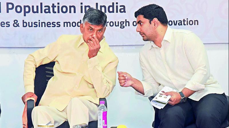 Chief Minister N. Chandrababu Naidu listens to IT minister N. Lokesh during Berkeley- Andhra Smart Village Open Innovation Forum at KL University on Thursday.