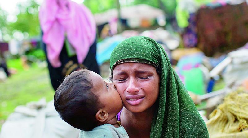 A Rohingya child kisses his mothers cheek as they rest after crossing over to Bangladesh (Photo:  AP)