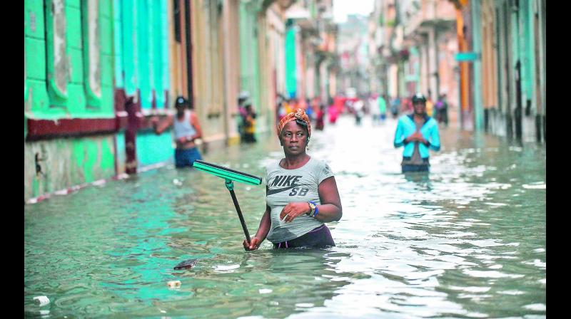 Cubans wade through a flooded street in Havana on Sunday. Hurricane Irma battered central Cuba on Saturday, knocking down power lines, uprooting trees and ripping the roofs off homes. (Photo: AP)