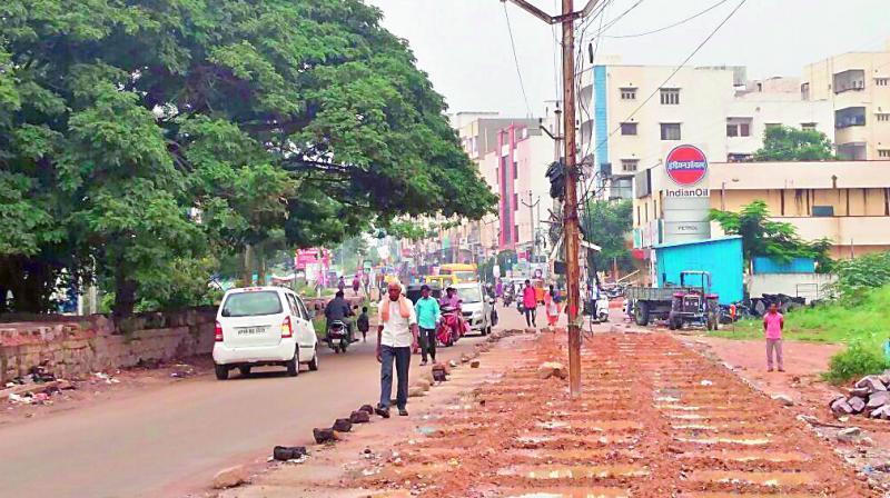 An electric pole prevents smooth flow of traffic on Shaikpet-Narsingi road (photo: DC)