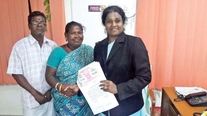Judge Jayanthi gives the allotment papers of TN Slum Clearance Board plot to the poor litigants at her office in Chennai (Photo: DC)