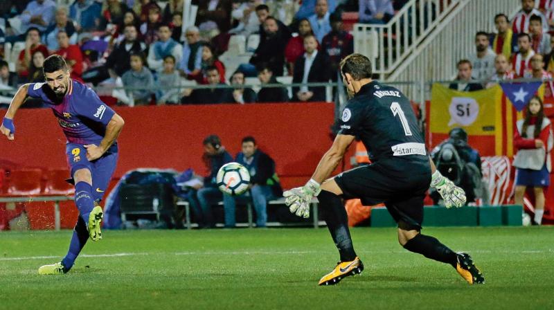 Barcelonas Luis Suarez scores past Girona goalkeeper Gorka Iraizoz in their La Liga match at the Montilivi Stadium in Girona on Saturday. The visitors won 3-0 (Photo: AP)