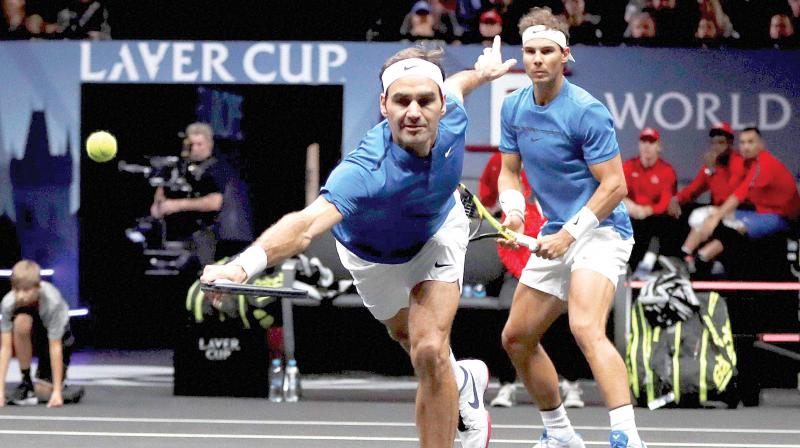 Team Europes Roger Federer reaches for a shot as doubles partner Rafael Nadal watches during their Laver Cup match against Team Worlds Jack Sock and Sam Querrey in Prague on Saturday. Federer-Nadal won 6-4, 1-6, 10/5.(Photo:  AP)