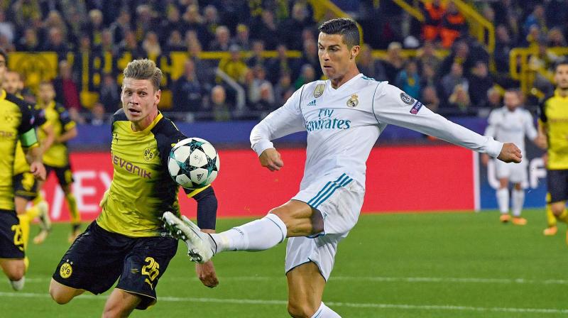 Real Madrids Cristiano Ronaldo (right) is challenged by Dortmunds Lukasz Piszczek in their Champions League Group H match in Dortmund on Tuesday. Real won 3-1 (Photo: AP)