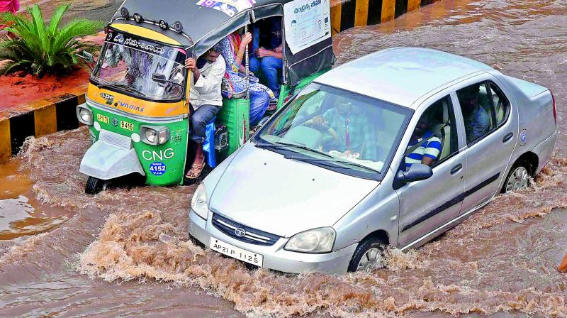 Motorists struggle to passs through the flooded road on Eluru road due to heavy rains on Friday morning (Photo: DC)