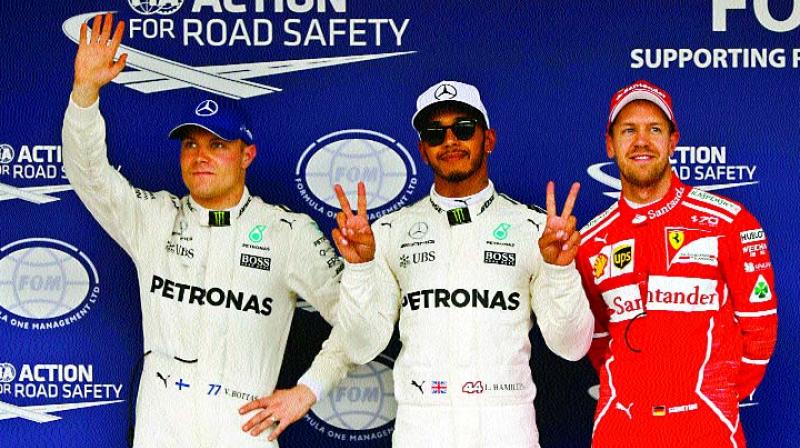 Lewis Hamilton (centre) poses with Valtteri Bottas (left) and Sebastian Vettel after getting pole position at Suzuka (Photo: AP)