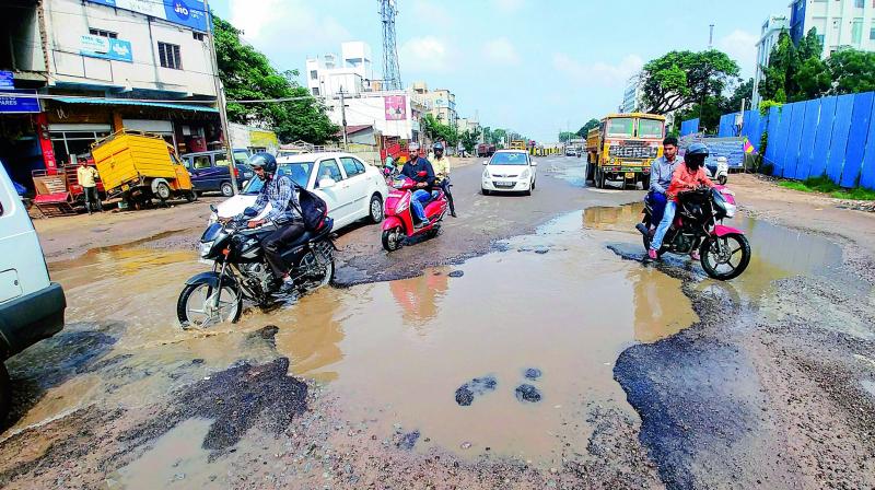 People try to cross the damaged road between Chintalkunta and LB Nagar following the heavy downpour in the past couple of days (Photo: DC)