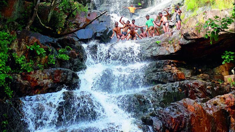 Villagers enjoy themselves at the naturally-formed waterfall located in the Saidapur forest area (Photo: DC)