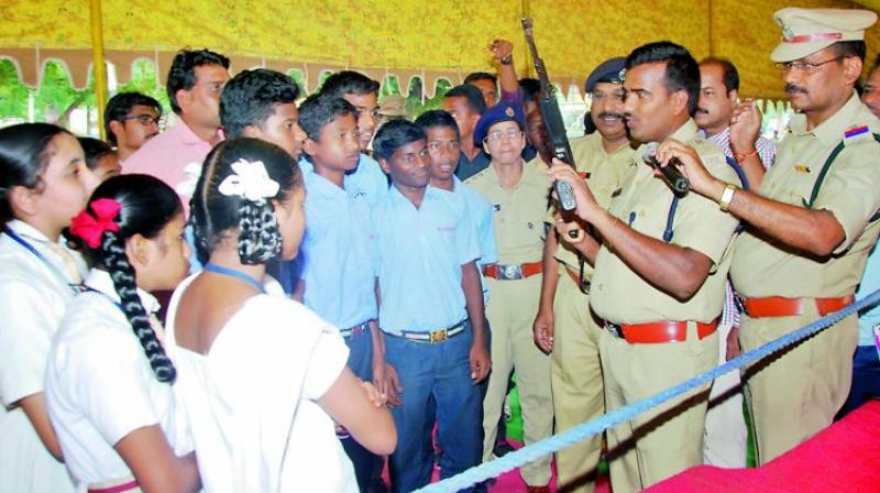Guntur Urban SP Ch. Vijaya Rao and other police personnel display weapons to schoolchildren during Open House at Police Parade grounds in Guntur. (Photo: DC)