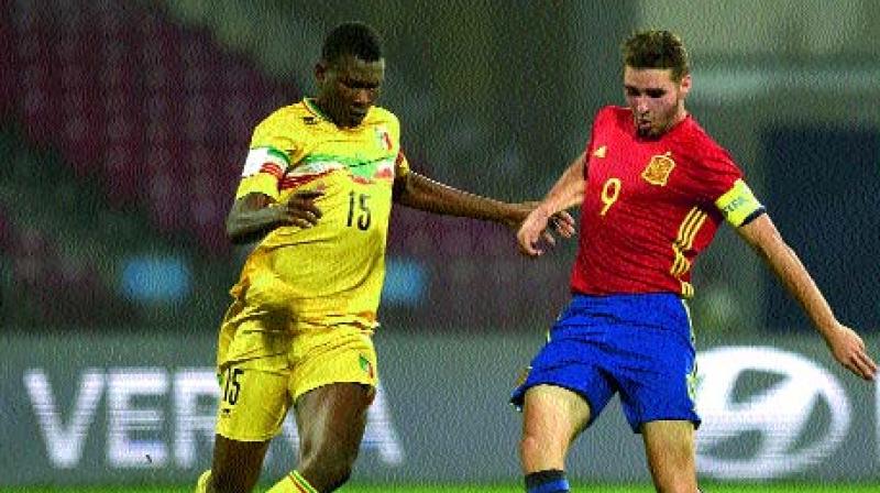 pains Abel Ruiz (right) in action against a Mali defender in their semi-final at the D.Y. Patil Stadium in Navi Mumbai on Wednesday. Spain won 3-1.(Photo: AFP)