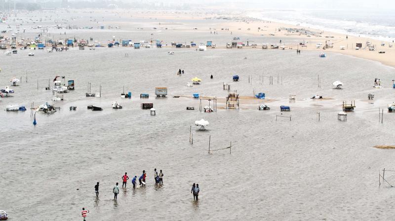 Boys playing cricket in inundated Marina beach on Friday.