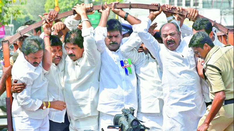 Policemen arrest YSR Congress city unit leader Velampalli Srinivas and others at Dharna Chowk, for conducting a dharna protesting registration of cases against Y.S. Jagan Mohan Reddy, in Vijayawada on Thursday. (Photo: DC)