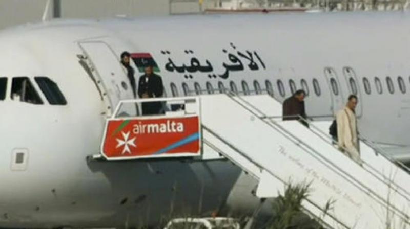 An Afriqiyah Airways plane stands on the tarmac at Maltas Luqa International airport as passengers depart. (Photo: AP)