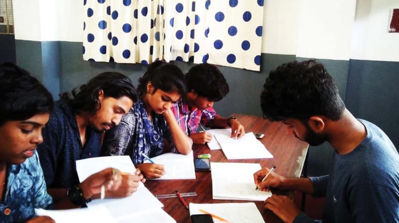 Youngsters write notes for flood-hit students at a school in Vadakara.