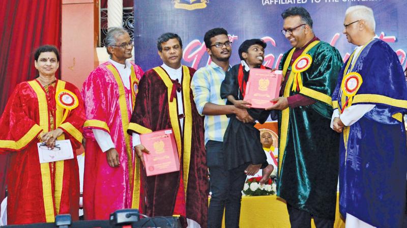 Carried by his kind roommate Immanuel, dwarf S Vincent is all smiles as he receives his medal and the B.A. (History) degree from chief guest Prof C. Raj Kumar, Founding Vice-Chancellor, O P Jindal Global University. (Image DC)