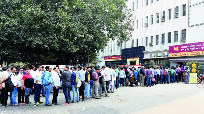 People queue up outside at ATM to withdraw money in New Delhi on Monday. With banks closed in many parts of the country, cash-strapped people started making beelines outside ATMs from early morning but with limited success as most of cash vending machines are running dry. (Photo:  PTI)