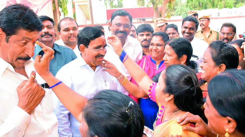 Women apply sandalwood paste to minister P. Narayanas face when he came to Nellore to distribute cheques to SHGs in Nellore on Monday. 	(Photo: DC)