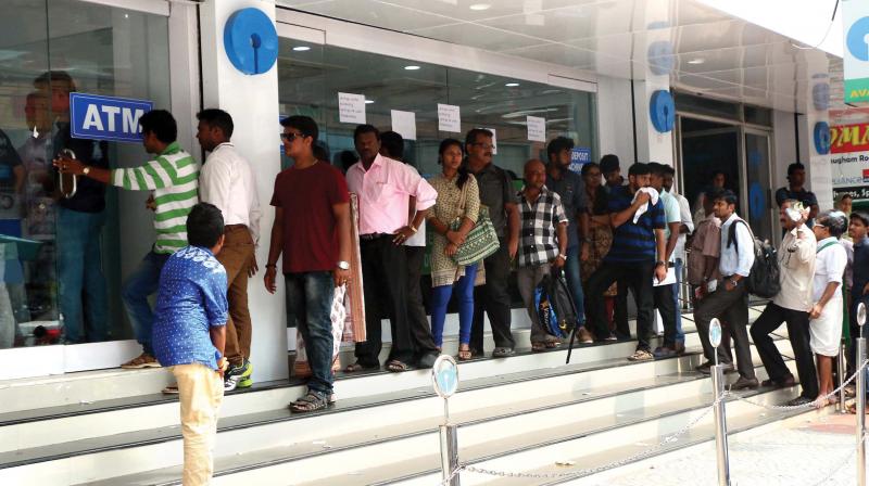 People stand in a queue at an ATM counter in Kochi on Saturday. (Photo: DC)