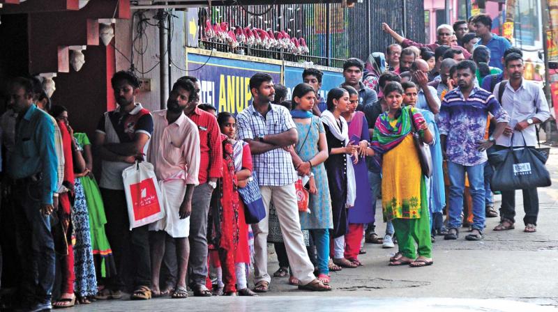 People stand in queue near an SBI ATM at Swaraj Round in Thrissur on Saturday. (Photo: ANUP K. VENU)