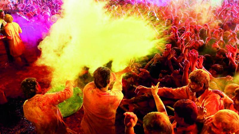 Devotees throw colour during Holi celebrations at the historical Govind Dev Ji temple in Jaipur on Sunday. (Photo: PTI)