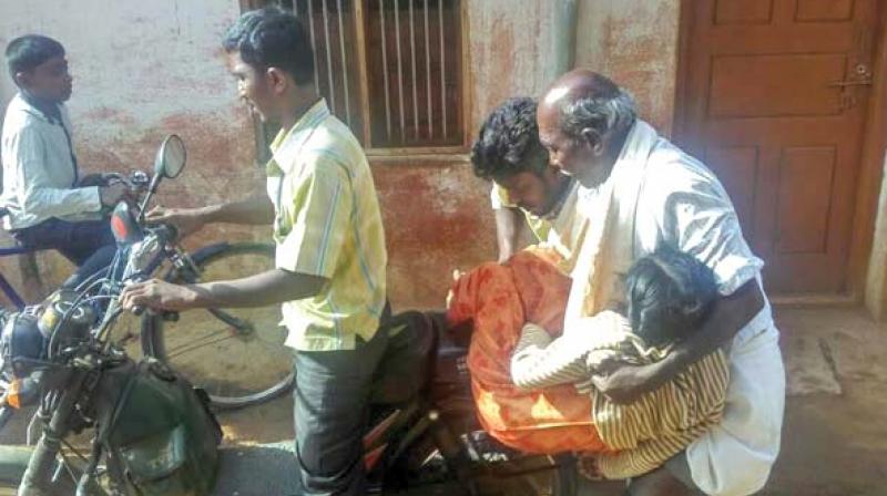 The kin of 21-year-old Rathnamma who was speech and hearing challenged, carrying her.