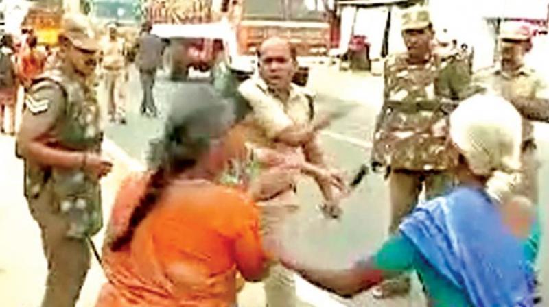A video grab shows DSP Pandiarajan assaulting a woman protester in Tirupur on Tuesday.