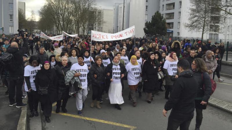 People march in the streets of Aulnay-sous-Bois, north of Paris, France, holding a sign reading \Justice for Theo\ during a protest, a day after a French police officer was charged with the rape of a youth, Monday. (Photo: AP)