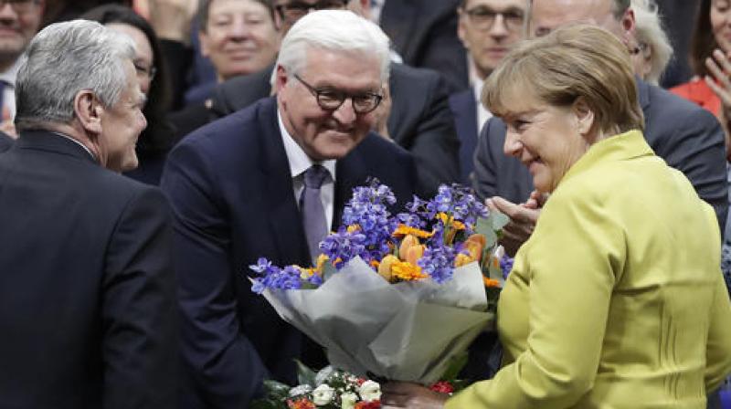 Newly elected German President Frank-Walter Steinmeier, center, is congratulated by German President Joachim Gauck, left, and German Chancellor Angela Merkel, right, after he was elected by the German parliamentary assembly on Sunday. (Photo: AP)