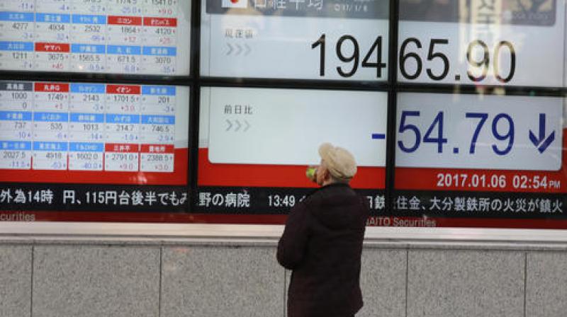 A man looks at an electronic stock board showing Japans Nikkei 225 index at a securities firm in Tokyo. (Photo:AP)